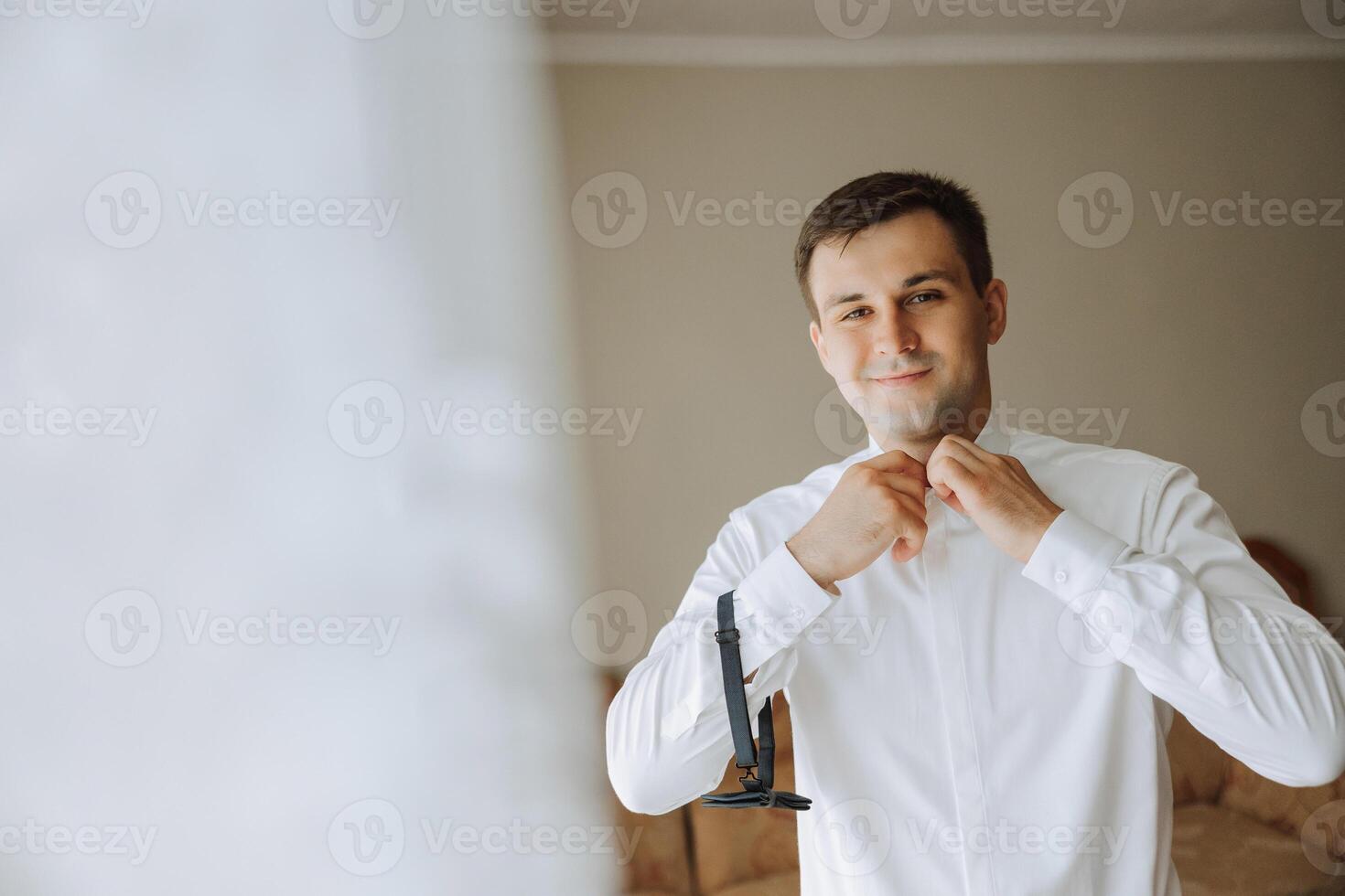 bedrijf shirt. een Mens in een wit overhemd vastmaakt de toetsen. jong politicus, mannetje stijl, zakenman knopen shirt, mannetje handen detailopname, Amerikaans, Europese zakenman foto