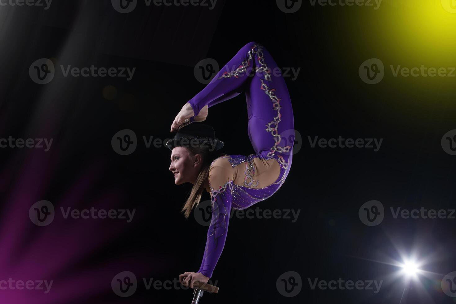 circus actrice presteert de aantal in een mooi rook. handleiding evenwicht Aan stokken. flexibel meisje lichaam.prestatie van een lucht gymnast in een circus foto