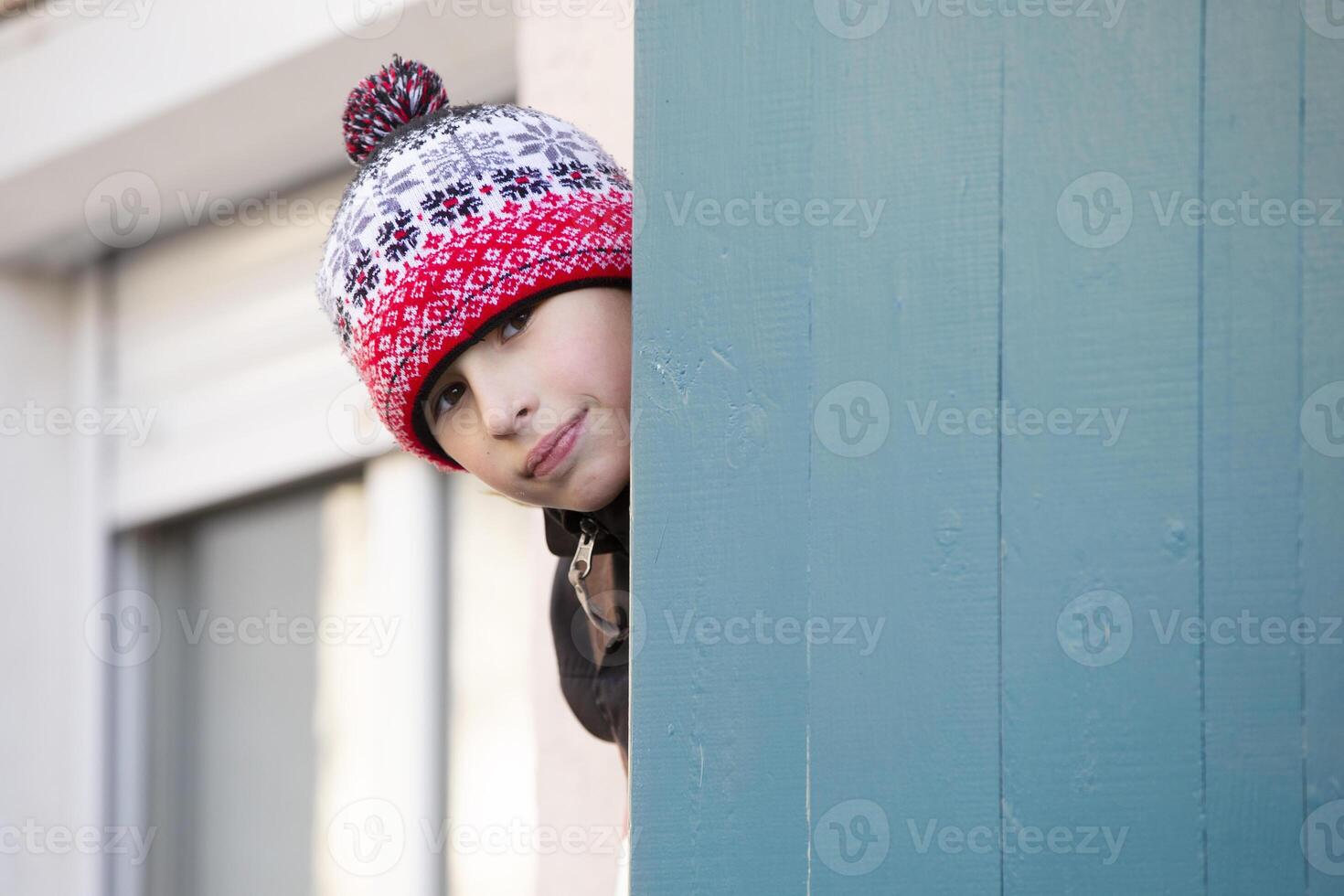 een weinig jongen looks uit van de deur. foto