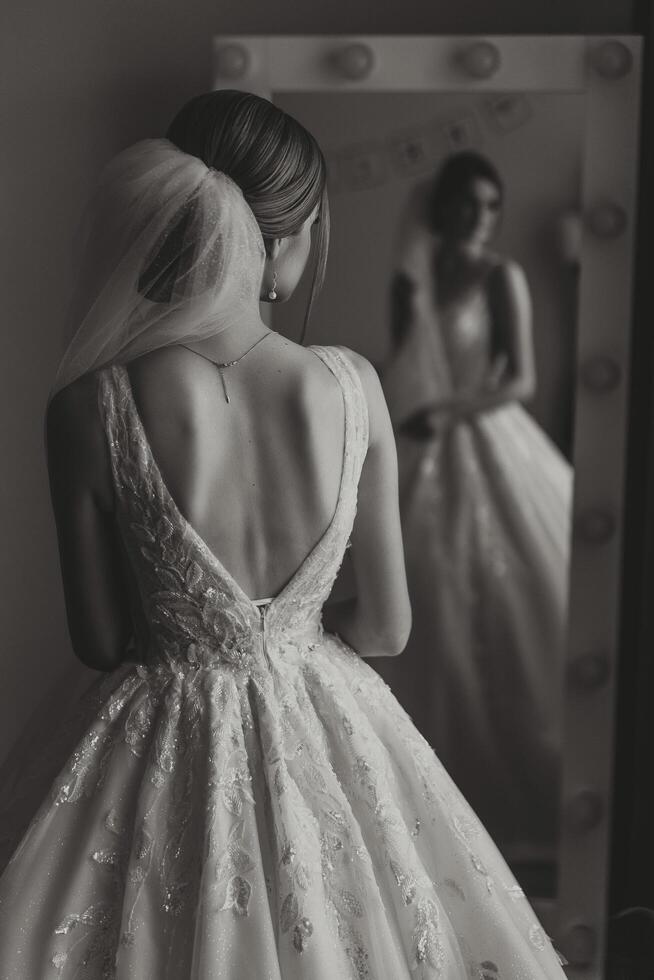 portret van de bruid in de hotel kamer. een mooi jong meisje is gekleed in een wit bruiloft jurk. modern bruiloft kapsel. natuurlijk verzinnen. foto