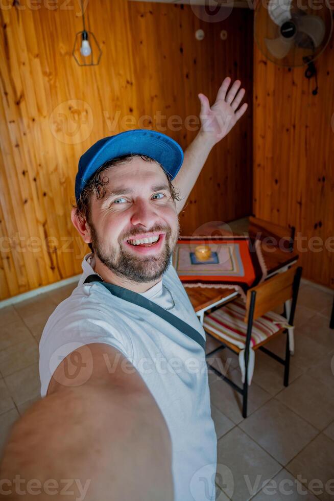 jong influencer gelukkig naar aankomen Bij zijn tijdelijk appartement nemen een selfie. foto