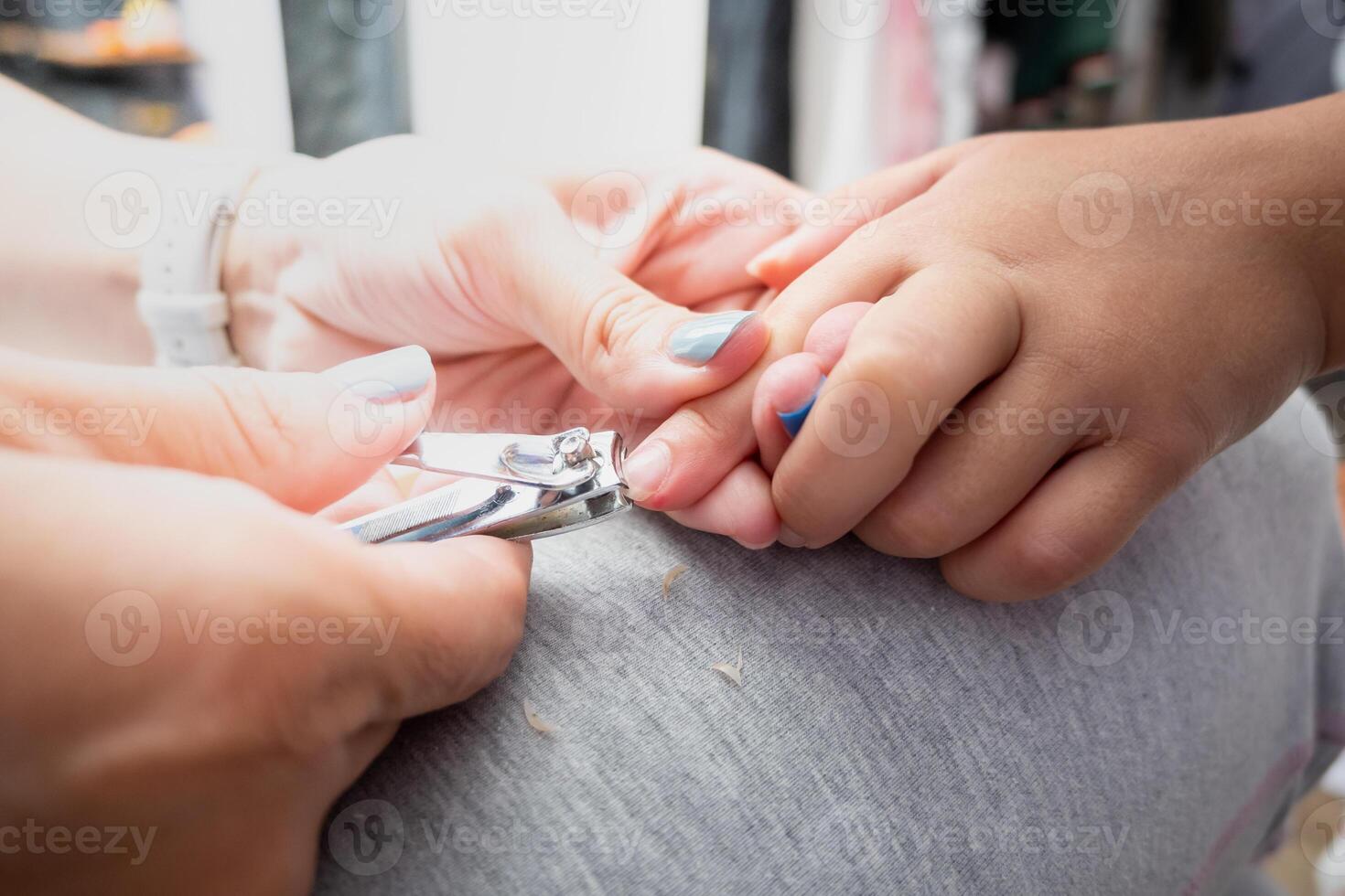 moeder snijdend haar van dochter nagels foto