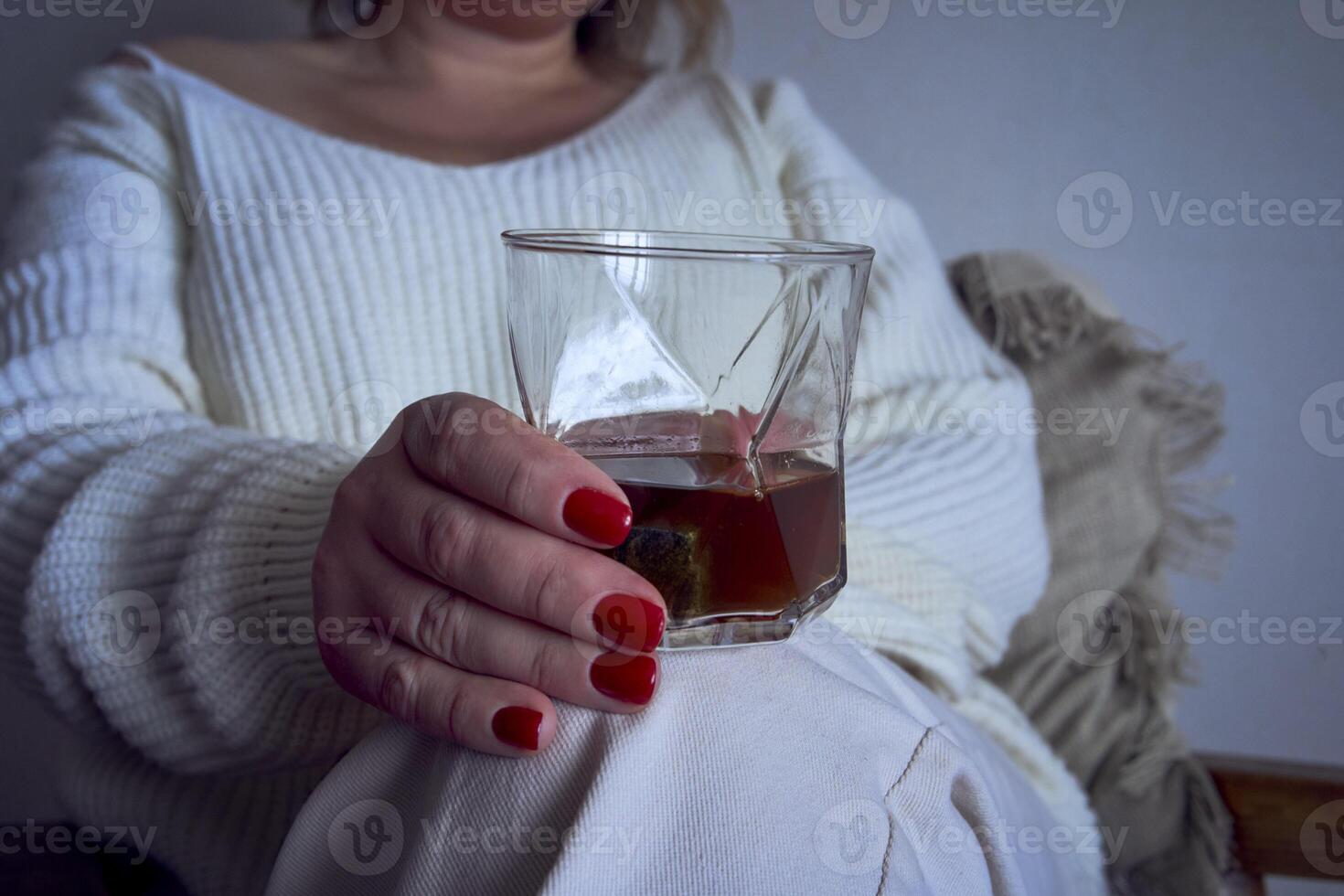 een middelgroot vrouw zit in een fauteuil lezing een boek en drinken whisky, een geschenk certificaat is De volgende naar haar foto