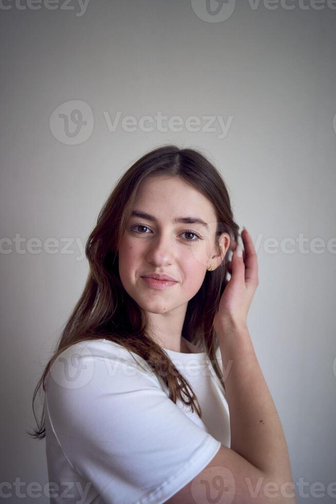 portret van een mooi tiener- meisje Aan een stoel in een helder kamer in een minimalistische stijl foto