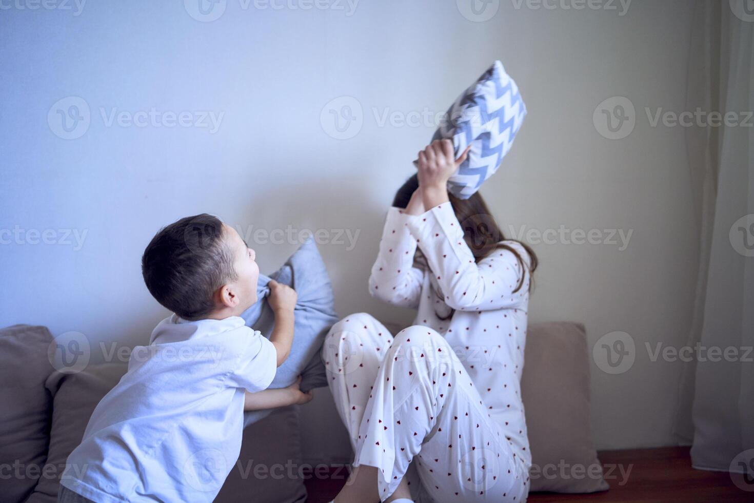 tiener- meisje en haar weinig broer zijn spelen en knuffelen in een hoofdkussen fort foto