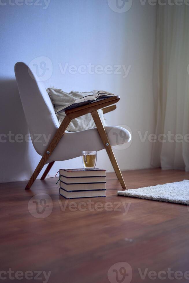 een ideaal plaats voor lezing en ontspannend, een wit fauteuil omringd door boeken in een helder kamer foto