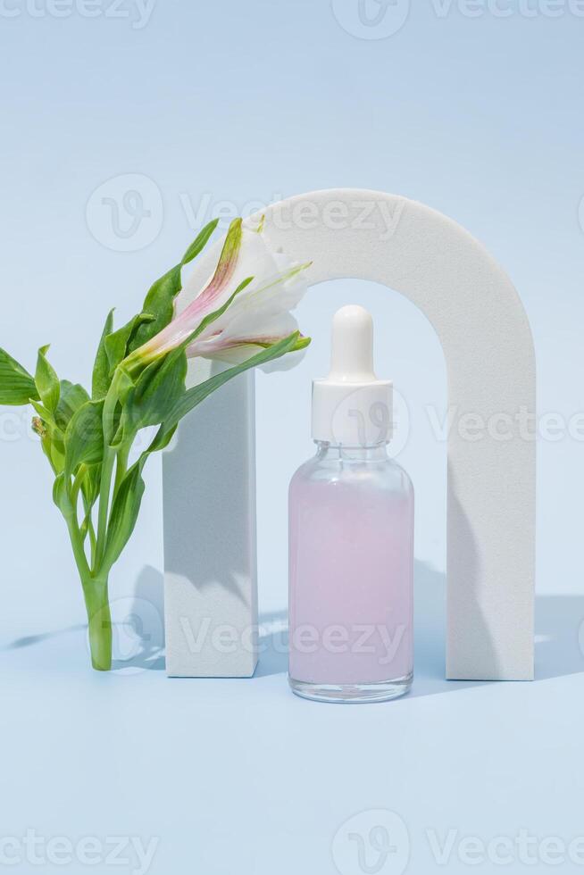 kunstmatig fles met lichaam en gezicht olie met alstromeria bloem in de boog, zomer natuurlijk cosmetica, serum, gelaats olie, tropisch concept foto