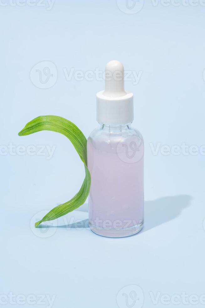 schoonheid spa medisch huidsverzorging en kunstmatig serum fles verpakking Aan blauw achtergrond met groen blad, gezond en geneeskunde concept foto
