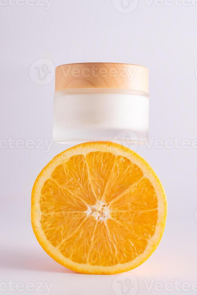 voorkant visie van een pot van vitamine c gezicht room Aan een oranje, de aanwezigheid van gesneden citrus fruit symboliseert de aanwezigheid van een groot bedrag van vitamine c in de room. foto