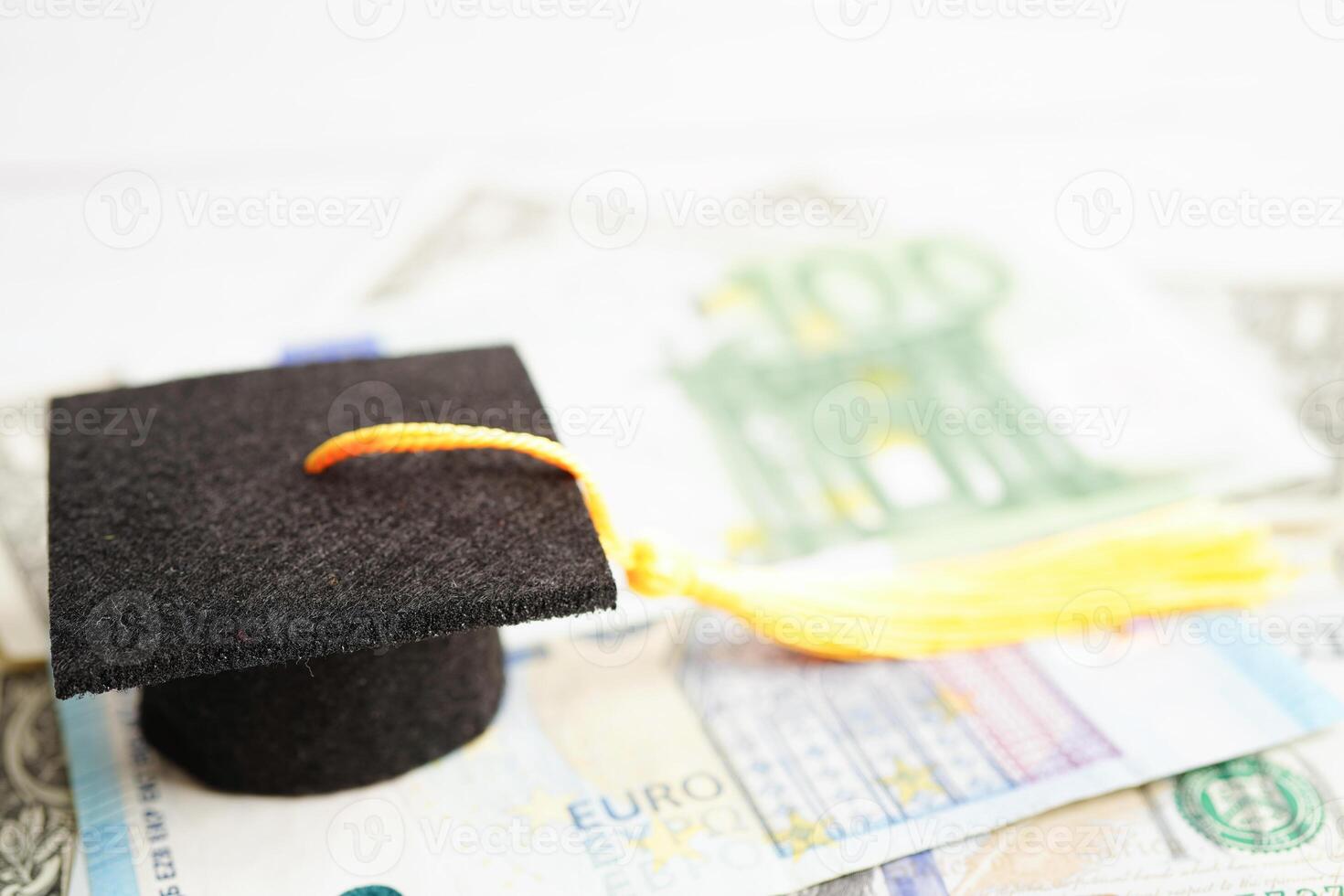 afstuderen gap hoed op euro en Amerikaanse dollar bankbiljetten geld, onderwijs studie vergoeding leren leren concept. foto