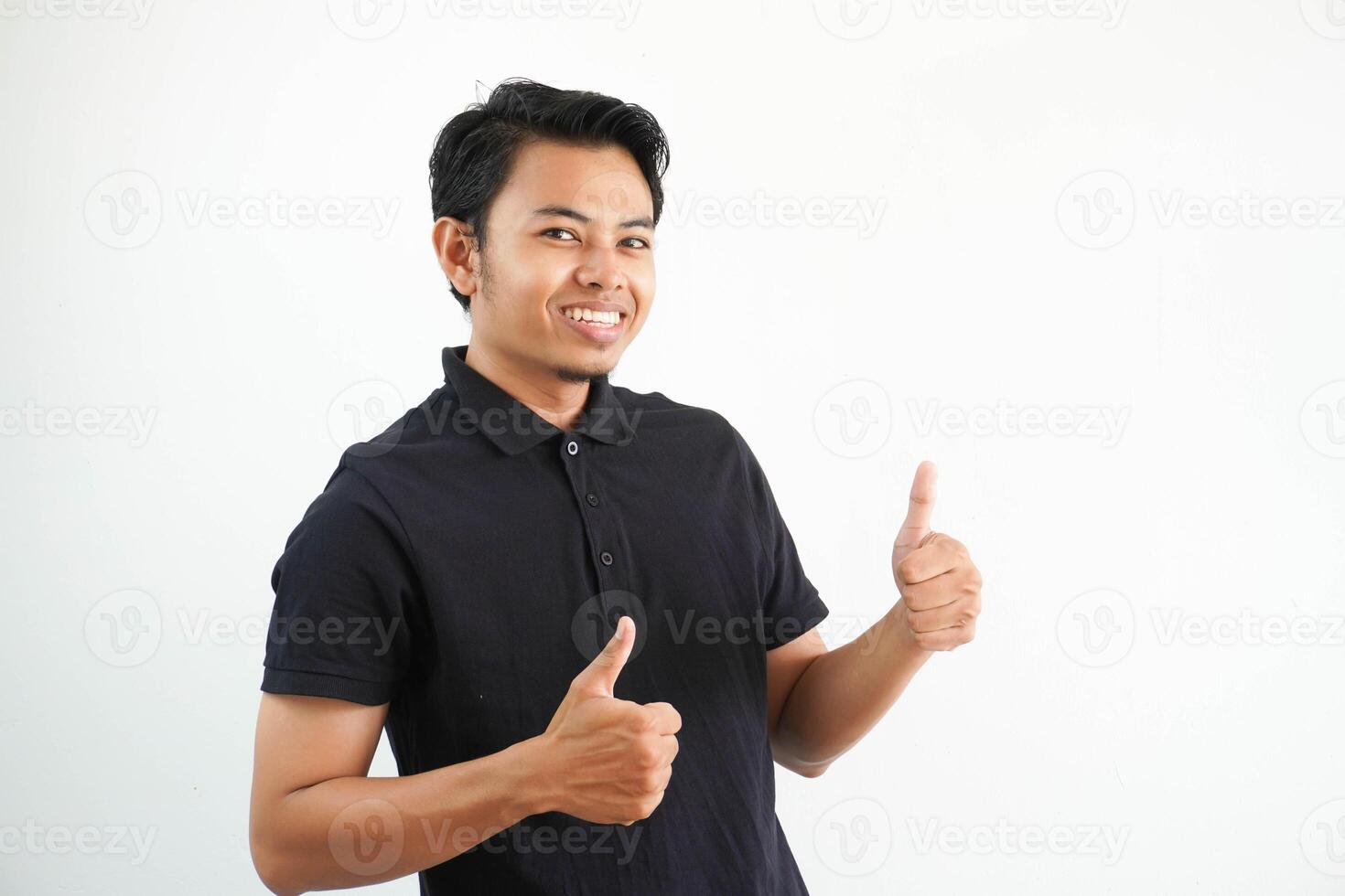 gelukkig of glimlachen jong Aziatisch Mens geven twee duimen omhoog vervelend zwart polo t overhemd geïsoleerd Aan wit achtergrond foto