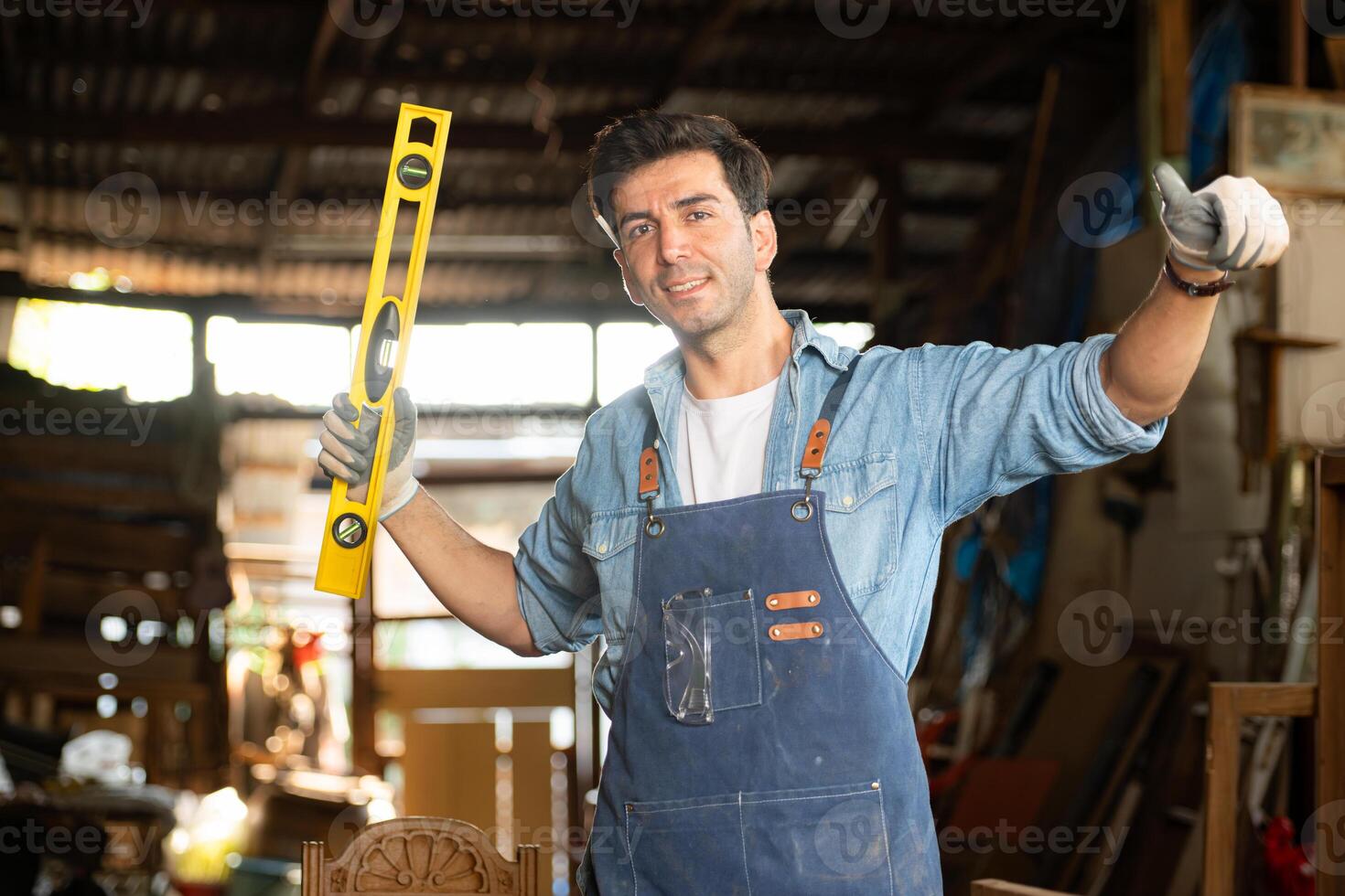 portret van een timmerman Holding een geest niveau in zijn werkplaats. foto