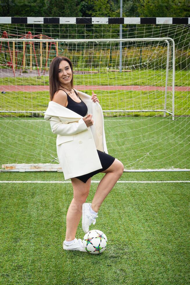 portret van een mooi vrouw Amerikaans voetbal speler in een streng kantoor pak. foto