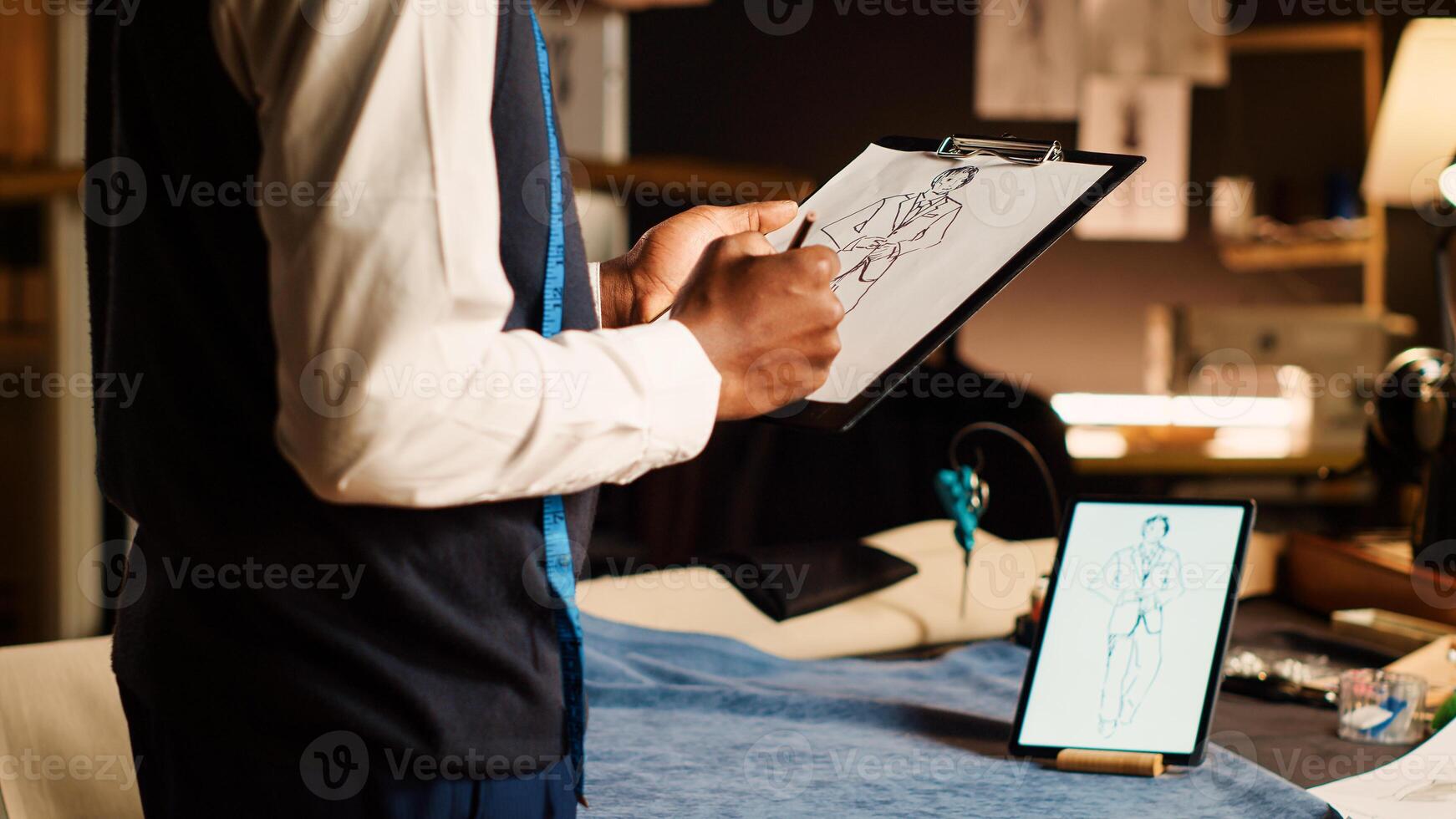 mannetje ontwerper tekening model- schetsen voor handgemaakt mode verzameling, textiel bouwen industrie. luxe couturier creëren schetsen van kleren voor modern items creatie in atelier. dichtbij omhoog. foto