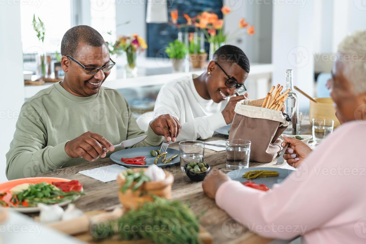 gelukkig afro Latijns familie aan het eten gezond lunch met vers groenten Bij huis - voedsel en ouders eenheid concept foto