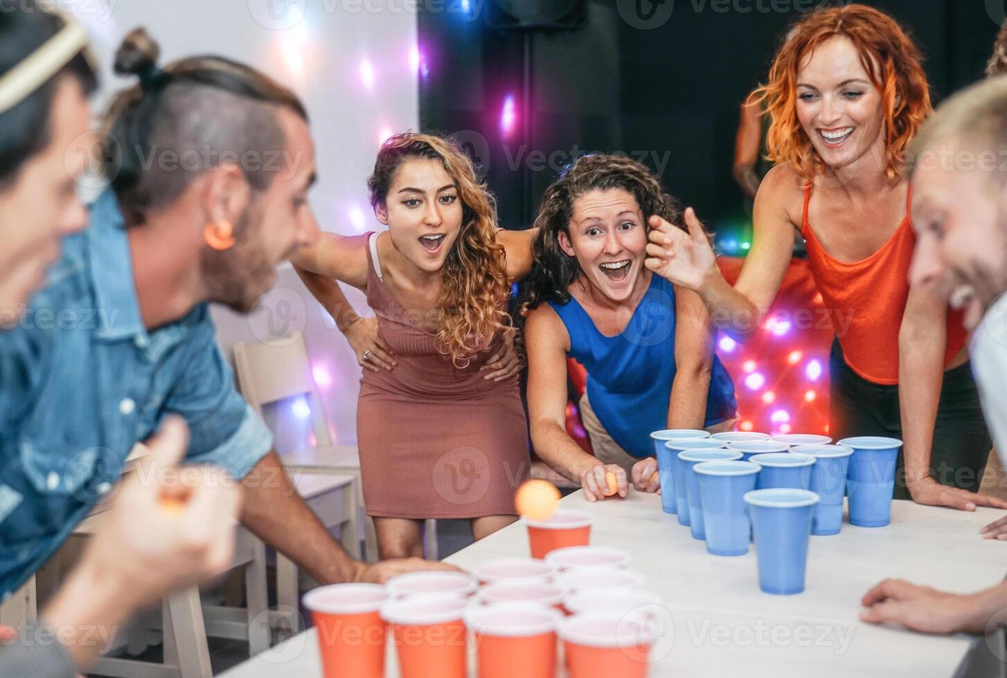 groep van gelukkig vrienden spelen bier pong in kroeg cocktail bar - jong millennials mensen hebben pret aan het doen partij alcohol spellen Bij nacht - vriendschap en jeugd levensstijl nachtleven concept foto