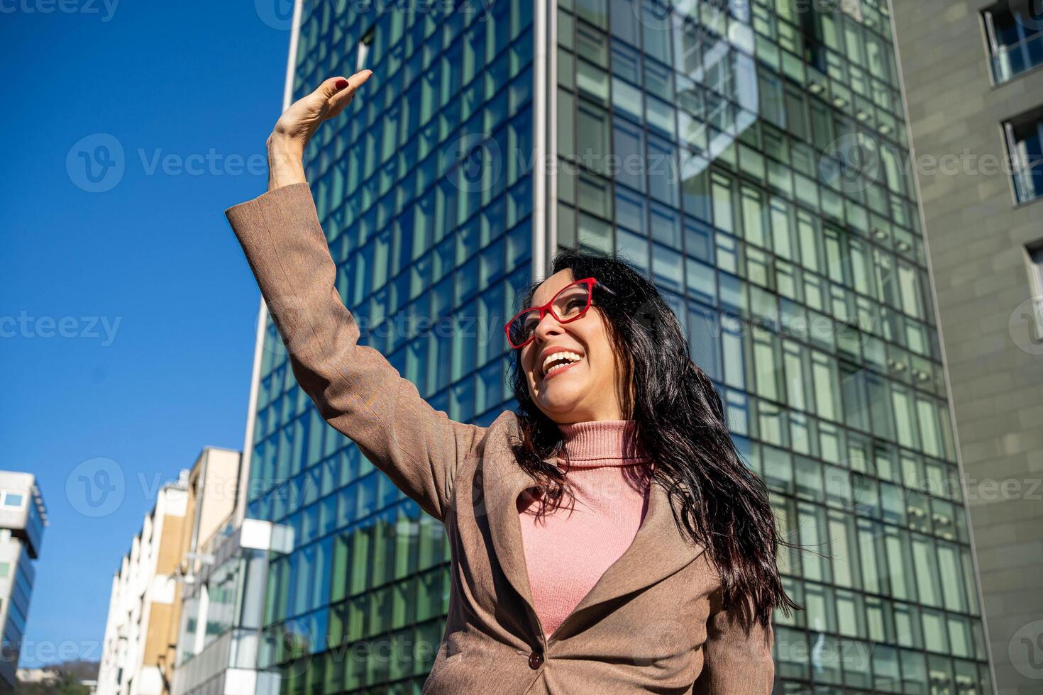 jong mooi uitvoerend vrouw vervelend bril, gelukkig golvend met hand- foto