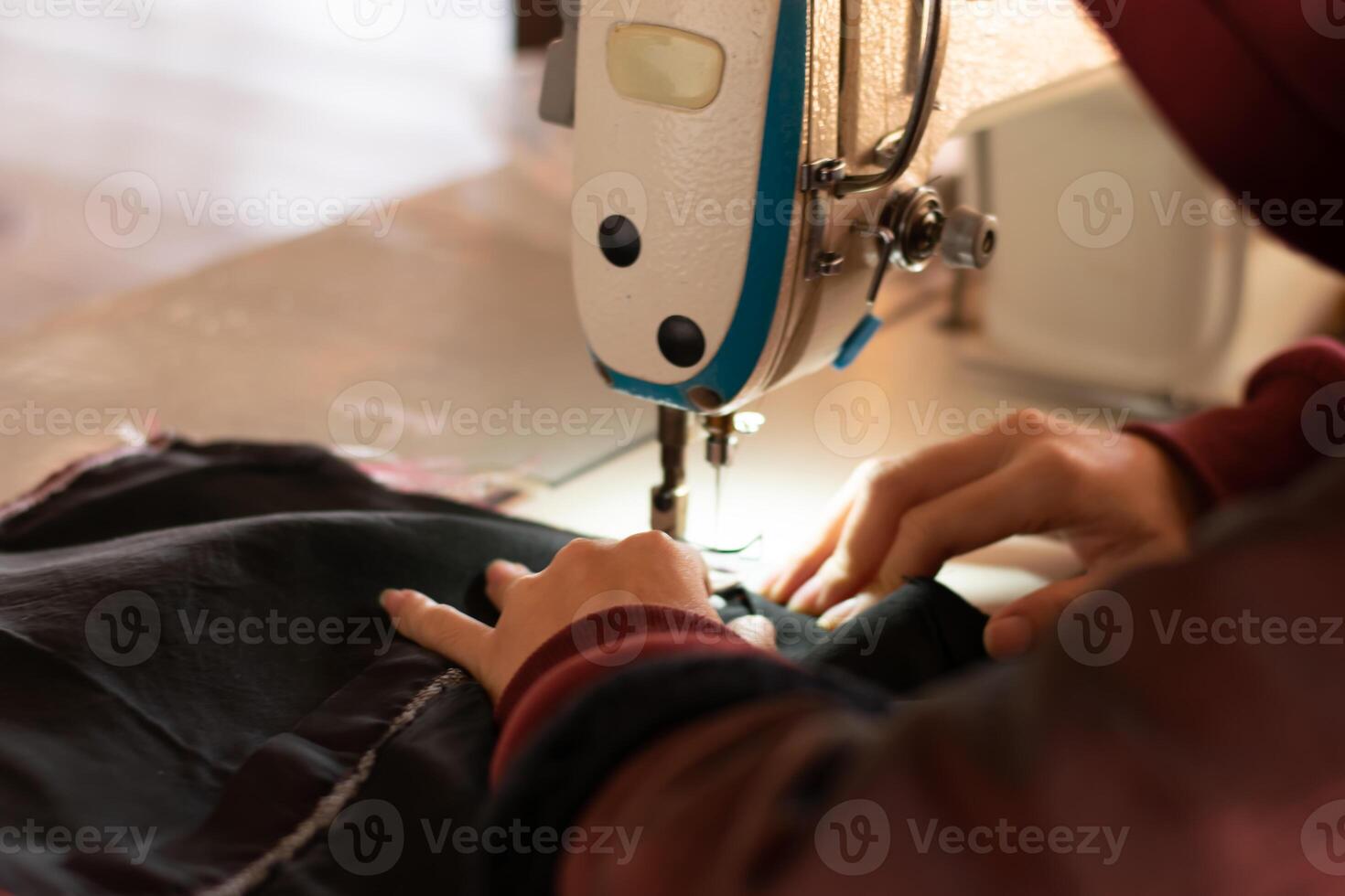 een vrouw handen zijn op maat gemaakt met modern naaien machines Bij werk, naaien kleren kussens en repareren technieken. foto