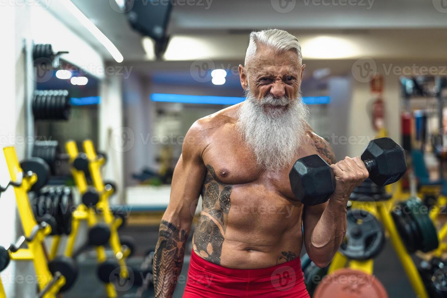 senior geschiktheid Mens aan het doen biceps krullen opdrachten binnen Sportschool - fit volwassen mannetje opleiding met halters in welzijn club centrum - lichaam gebouw en sport gezond levensstijl concept foto