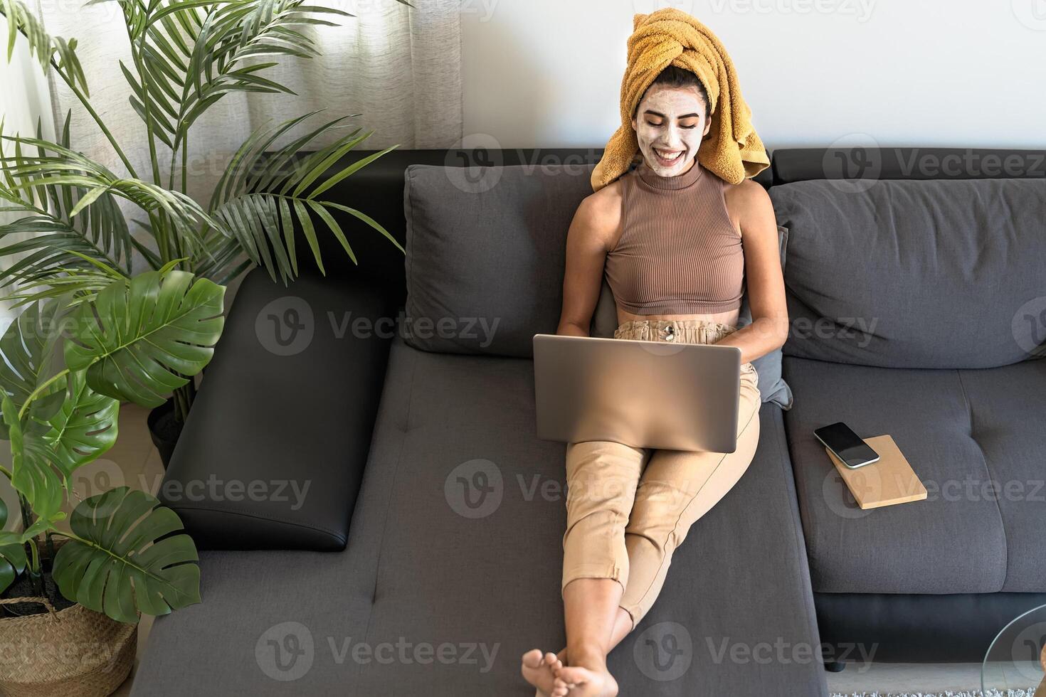 jong vrouw gebruik makend van laptop terwijl hebben huid zorg dag Bij huis foto