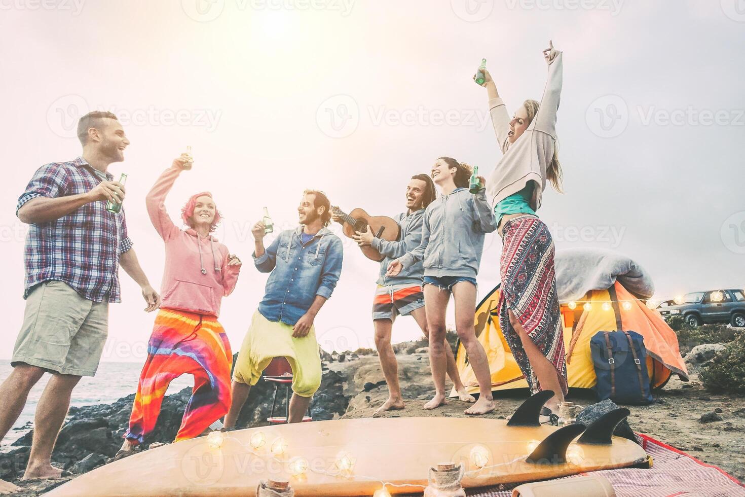 gelukkig vrienden dansen en hebben pret maken een strand partij in de camping - jong mensen lachend en drinken bieren terwijl camping De volgende oceaan - reis, vakantie, levensstijl concept foto