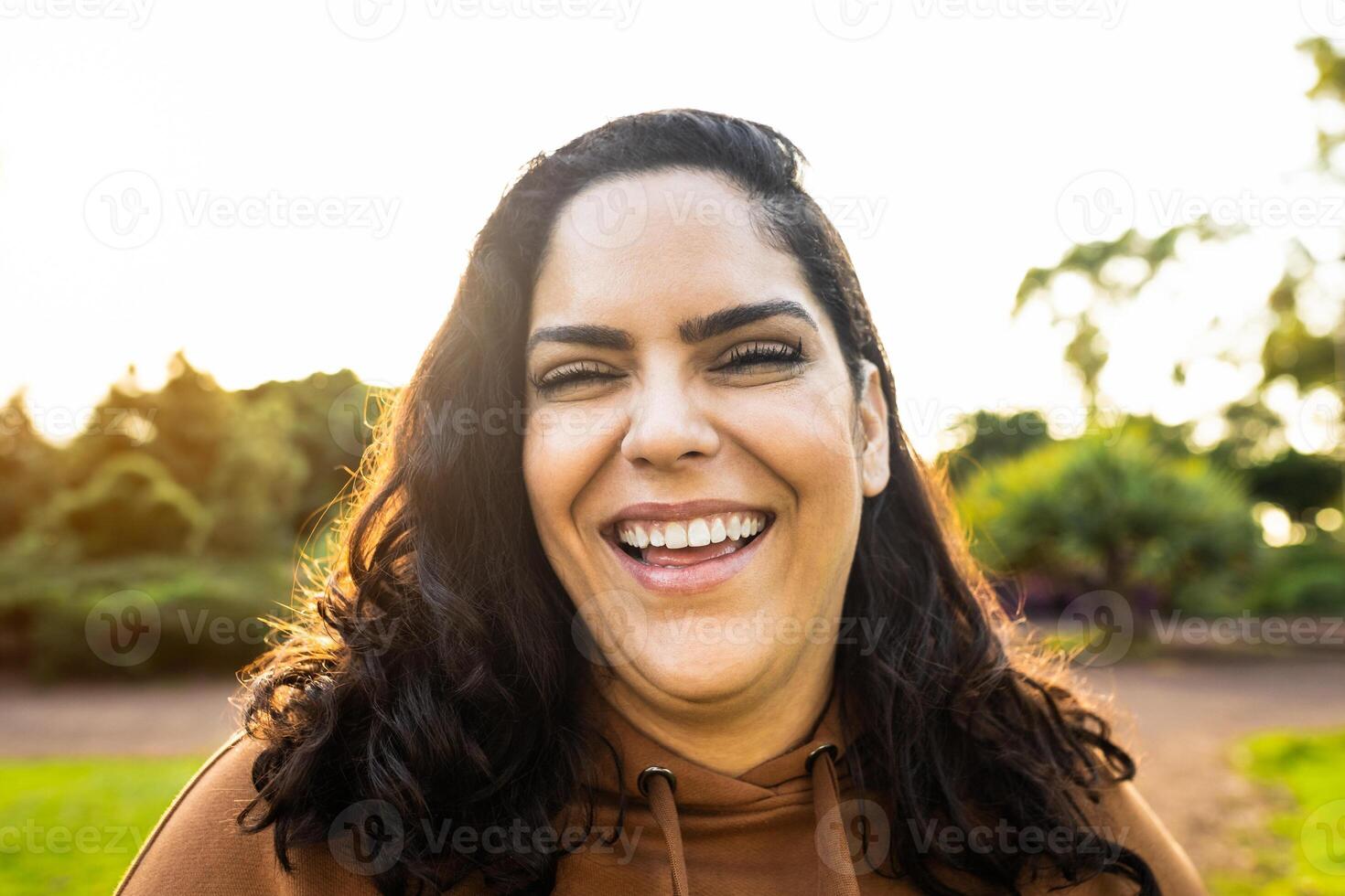 gelukkig vrouw hebben pret glimlachen in de camera in een openbaar park foto