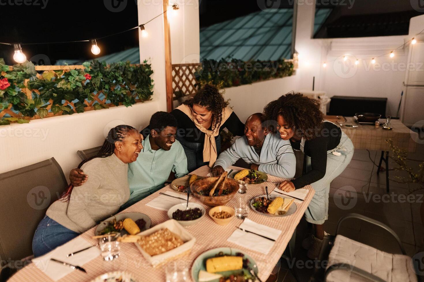 gelukkig Afrikaanse familie dining samen Aan huis patio foto