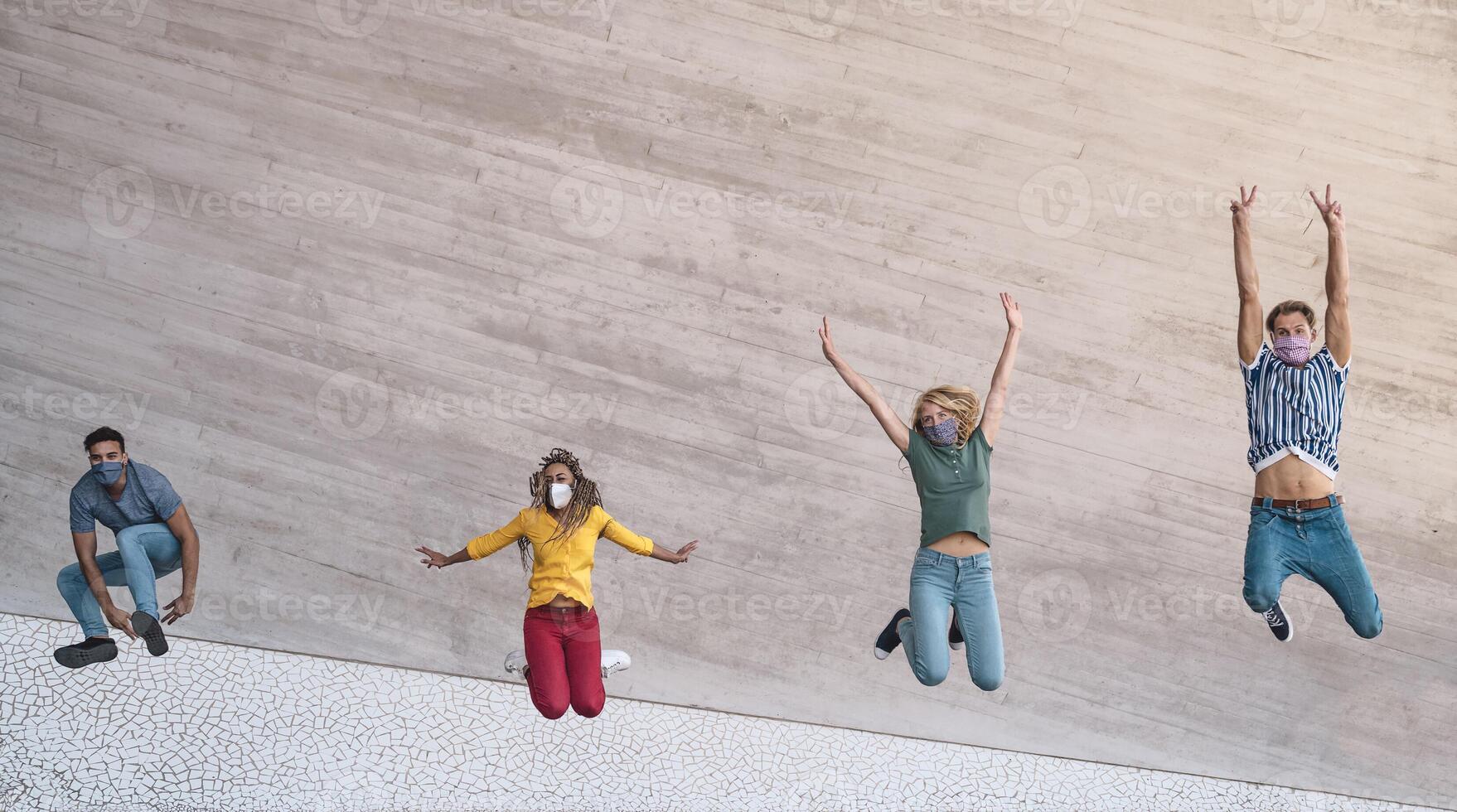 jong vrienden vervelend gezicht masker jumping buitenshuis - gelukkig mensen hebben pret in stad na corona virus quarantaine - jeugd millennial generatie vriendschap en Gezondheid zorg concept foto