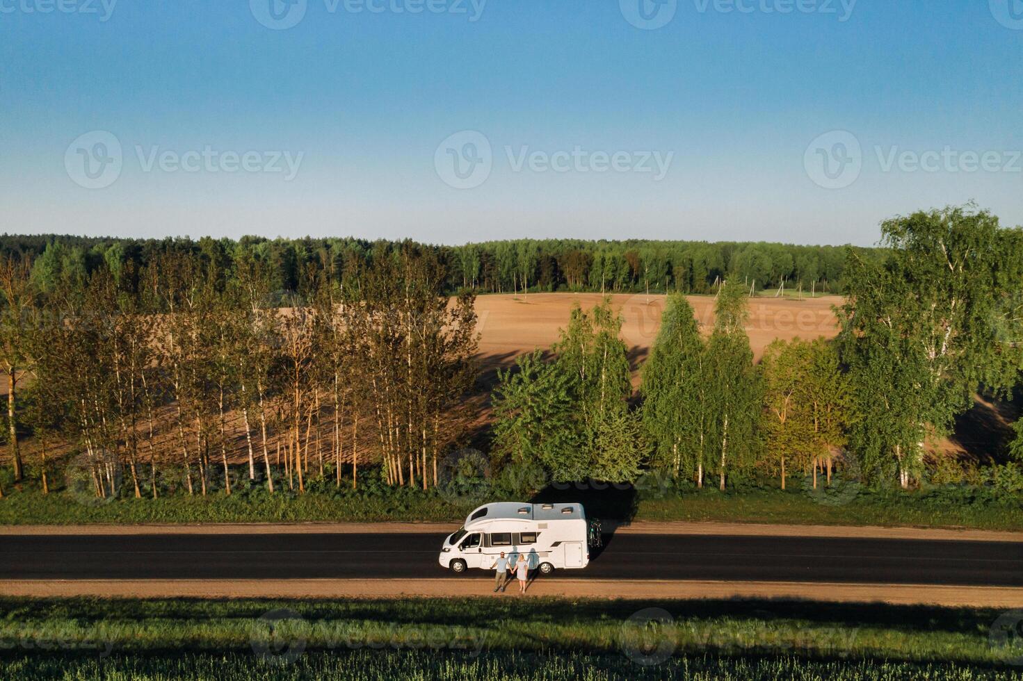 een paar is staand Aan de weg in de buurt hun camper Bij dageraad foto