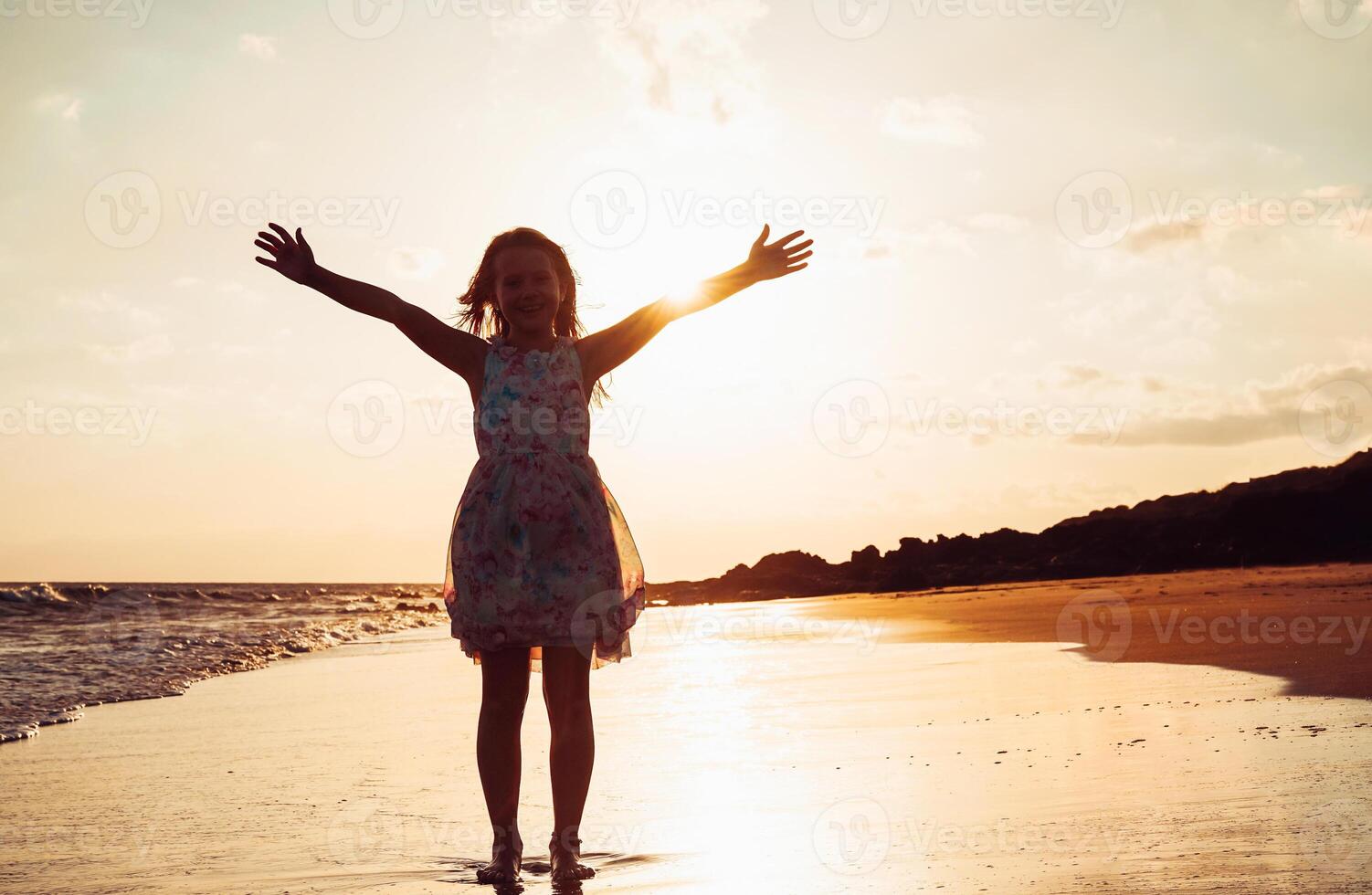 gelukkig kinderen hebben pret Aan de strand Bij zonsondergang - aanbiddelijk weinig kind verspreiden handen langs de kust - jeugd, vrijheid en geluk concept - verzadiging filter foto