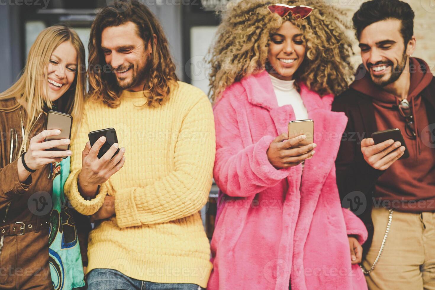 groep van vrienden aan het kijken Aan hun mobiel telefoons buitenshuis - millennial jong mensen hebben pret met nieuw technologie smartphone trends - generatie z, sociaal media, tech en jeugd levensstijl concept foto