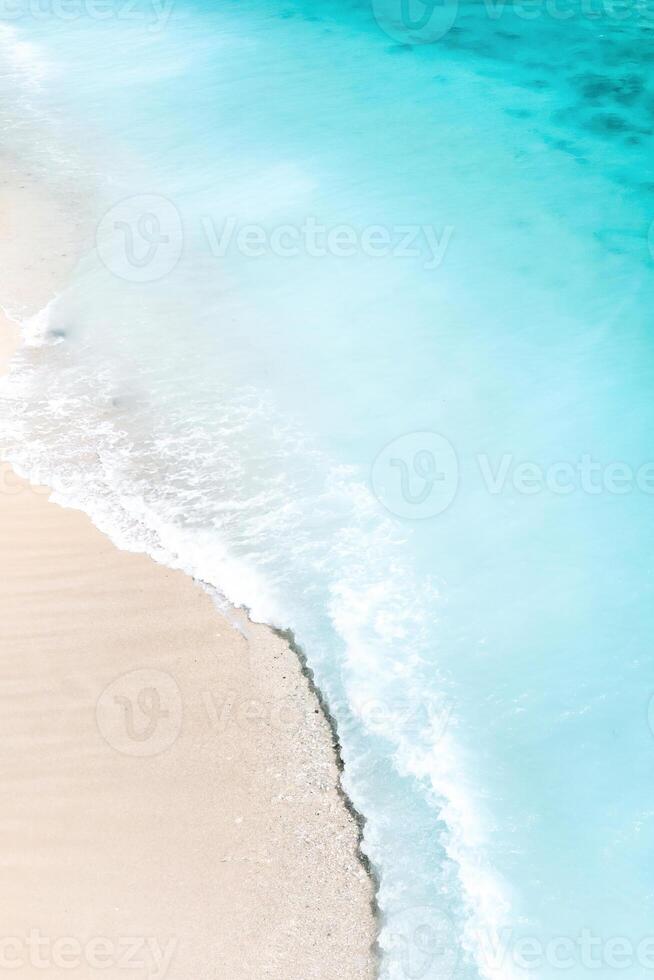 tropisch strand met een vogel oog visie van de golven breken Aan de tropisch gouden zanderig strand. zee golven voorzichtig lus langs de mooi zanderig strand. foto