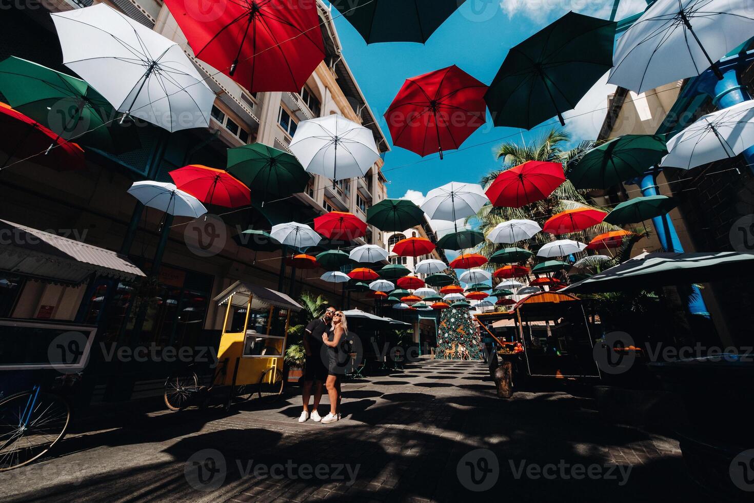haven louis, mauritius, een zwart gekleed paar staat Aan een paraplu-overdekt stad steeg leidend naar de hoofdstad foto