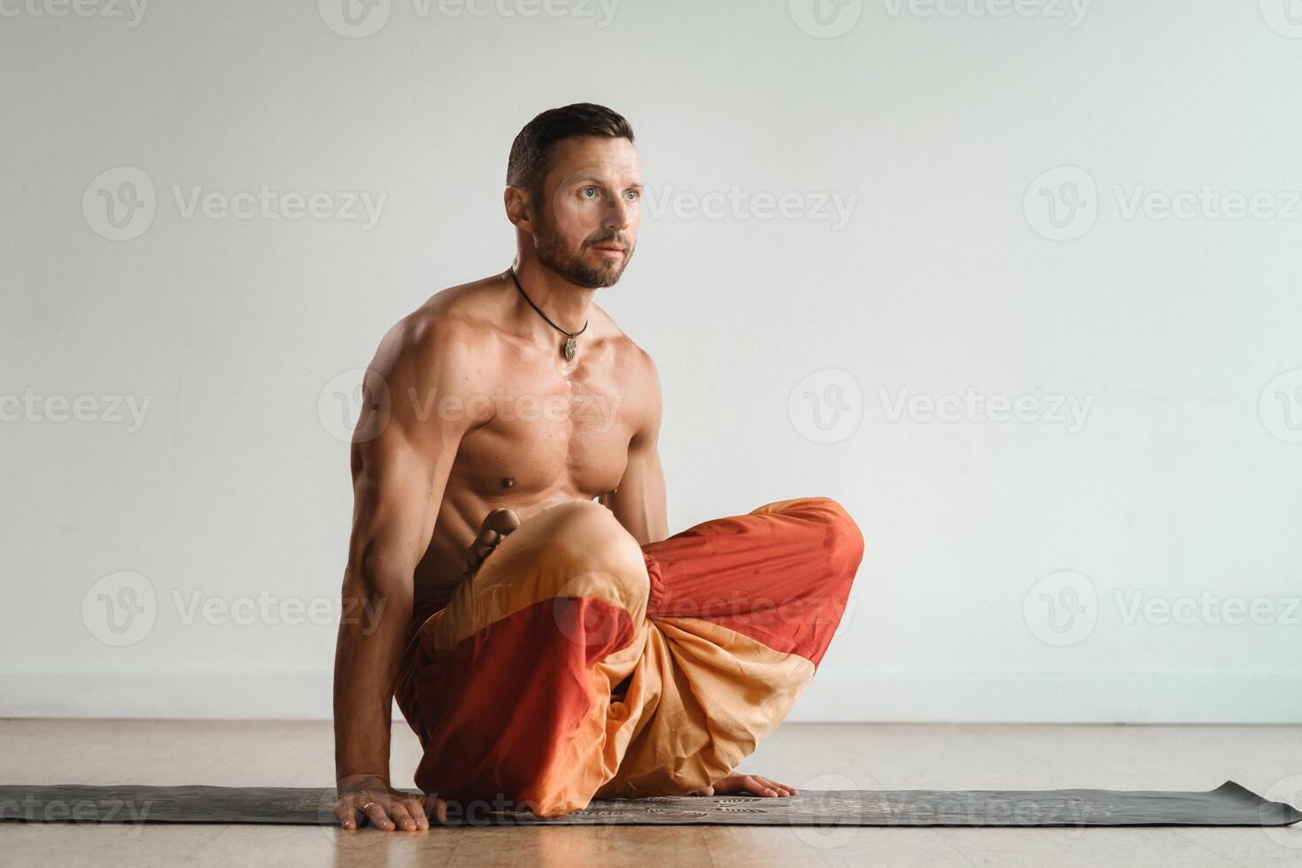 een Mens met een naakt torso doet yoga staand Aan zijn handen binnenshuis. geschiktheid trainer foto