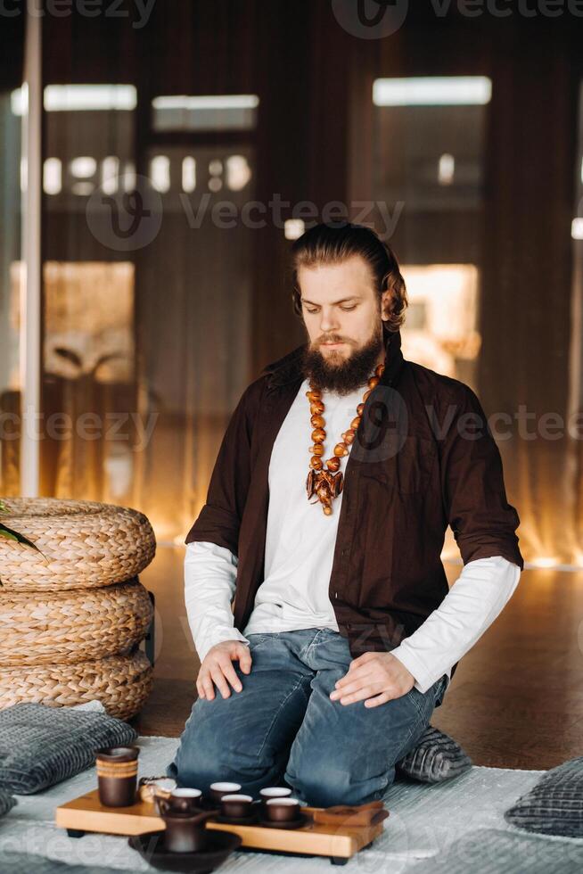 de thee meester is voorbereidingen treffen naar houden een thee ceremonie in de interieur foto