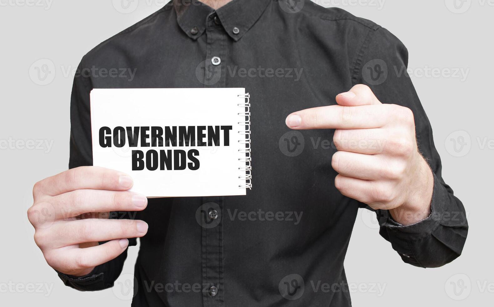 zakenman Holding een wit kladblok met tekst regering obligaties, bedrijf concept foto