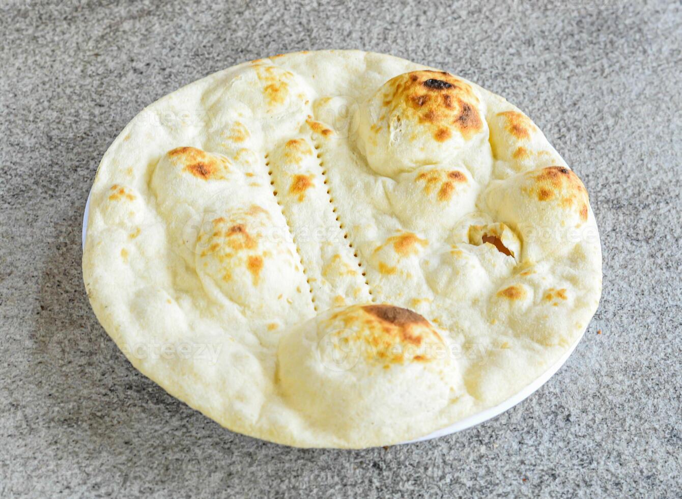 tandoori duidelijk naan, oma, roti, kulcha en pita brood geserveerd in bord geïsoleerd Aan grijs achtergrond top visie van Pakistaans en Indisch specerijen voedsel foto