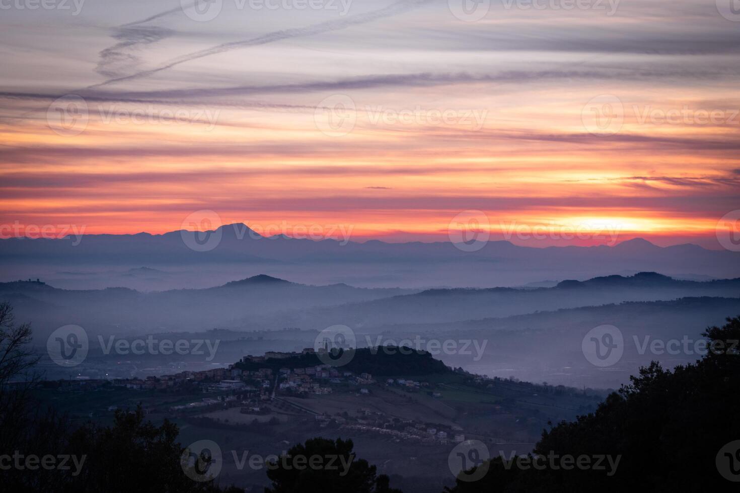 zonsondergang landschap Aan de bergen brand in de lucht met wolken en dramatisch gevoel zon gaan naar beneden terwijl mist knuffels allemaal de valleien foto