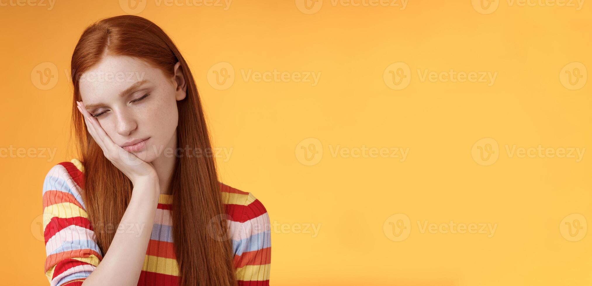 moe schattig roodharige vrouw leerling uitgeput voelen slaperig vallen in slaap staand leunend gezicht palm dichtbij ogen werken deeltijd nacht verschuiving, dagdromen ontbrekend energie wil ik slaap bed oranje achtergrond foto