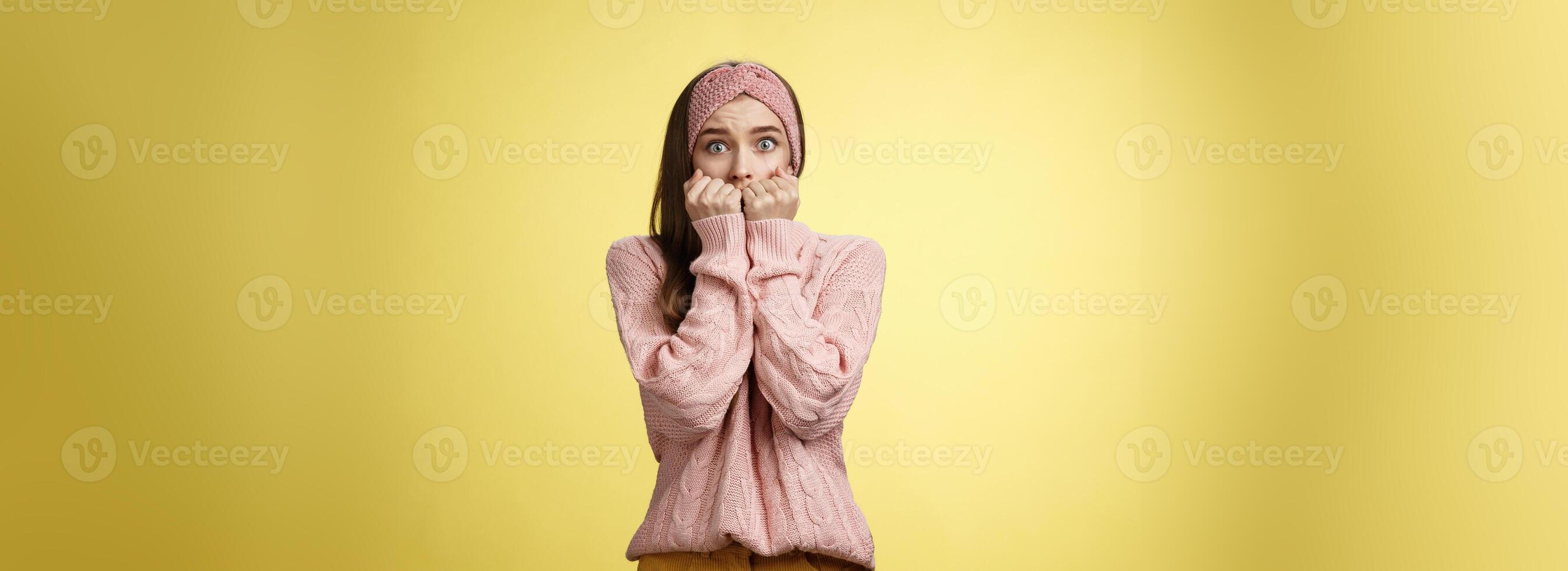 verbijsterd bang timide onzeker schattig jong meisje bang hijgen van angst drukken handen naar mond staand in verdoving geschokt, geschokt verbijsterd tegen geel achtergrond wezen slachtoffer van misbruik foto