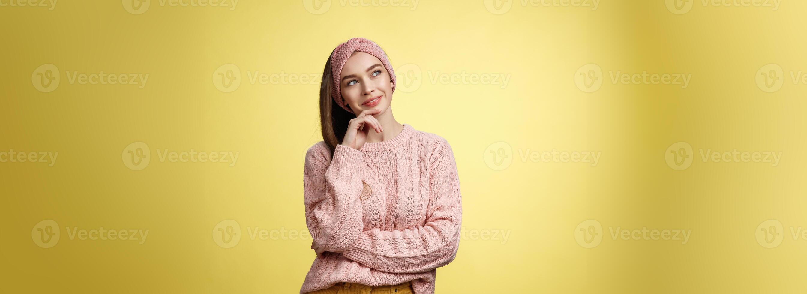 dromerig aantrekkelijk en elegant schoolmeisje in gebreid warm trui, hoofdband, denken net zo glimlachen tevreden en sluw hebben idee, op zoek Bij bovenste links hoek attent, dagdromen, planning foto