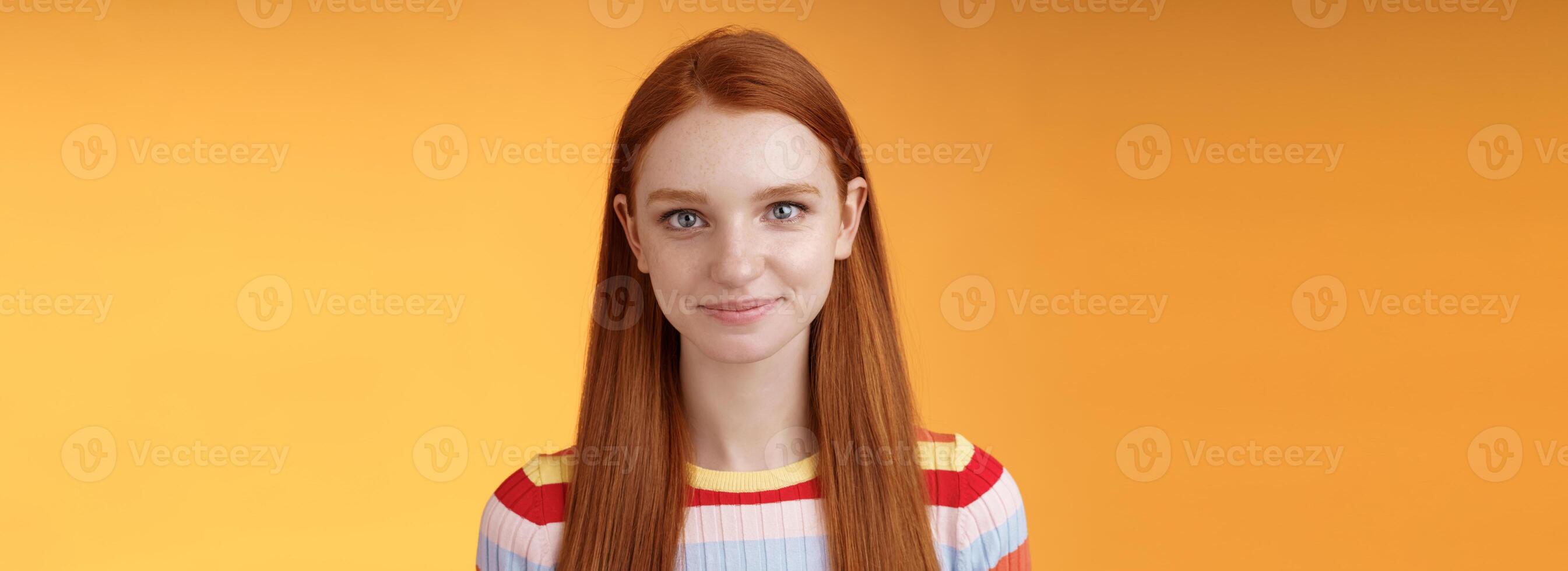 aantrekkelijk zelfverzekerd roodharige meisje bemoedigend haarzelf kijken spiegel zelfverzekerd bereiden interview toespraak staand oranje achtergrond grijnzend gefascineerd luisteren pratend terloops foto