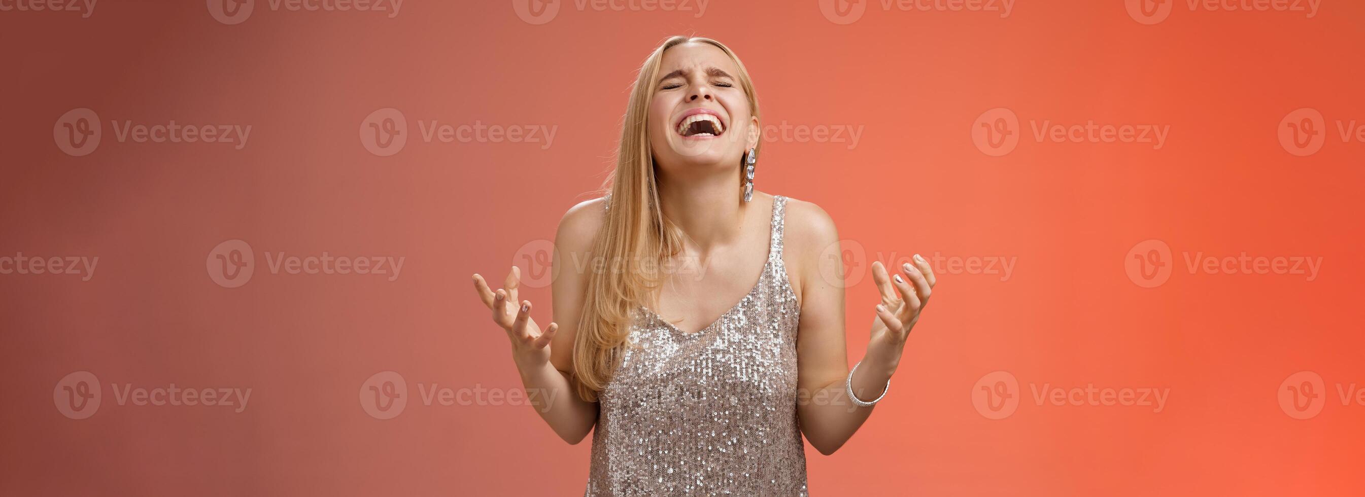 opgelucht gelukkig charmant blond vrouw dank god geschreeuw Ja vieren verheugt winnen staand rood achtergrond dichtbij ogen lachend geluk klemmen vuisten zege triomf gebaar, droom kwam waar foto