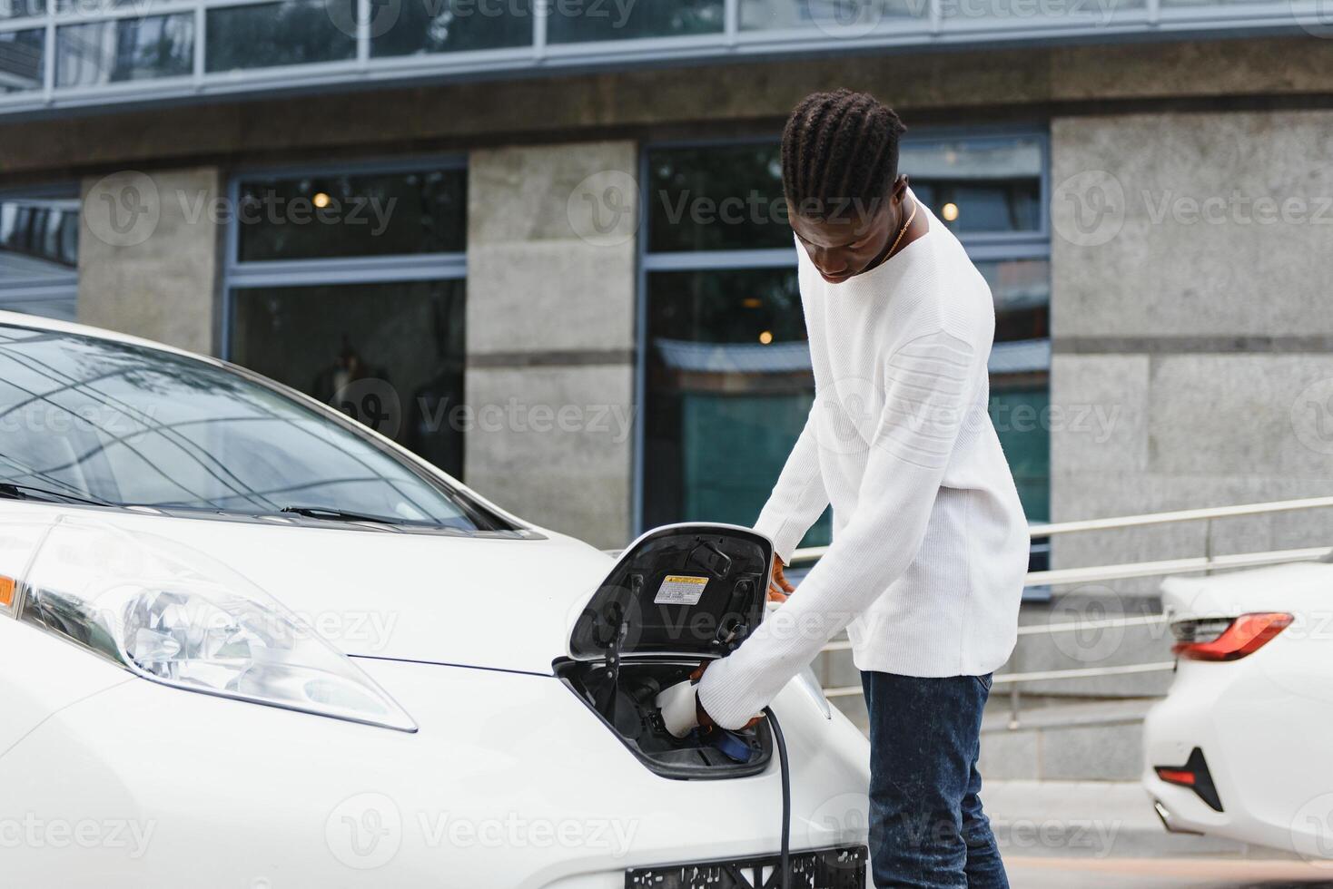 Afrikaanse Amerikaans Mens opladen zijn elektrisch auto. foto