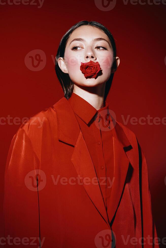 elegant dame met rood bedenken en helder lippen, poseren in een zwart jurk Aan een wit achtergrond foto