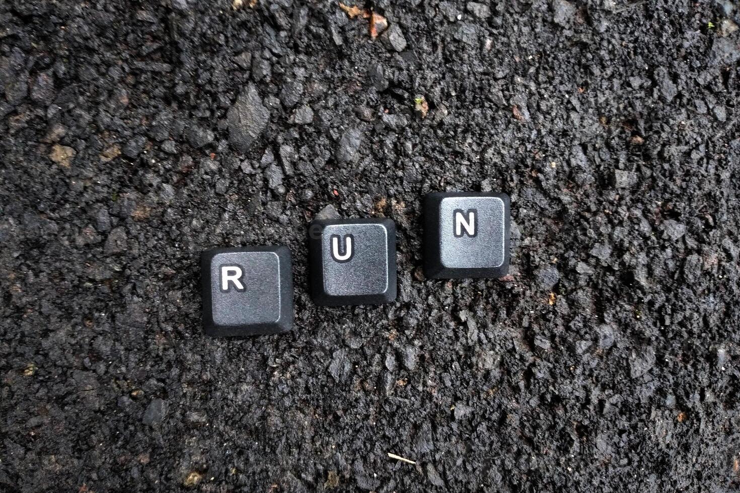 de woord rennen geschreven in zwart toetsenbord sleutels Aan de asfalt achtergrond foto