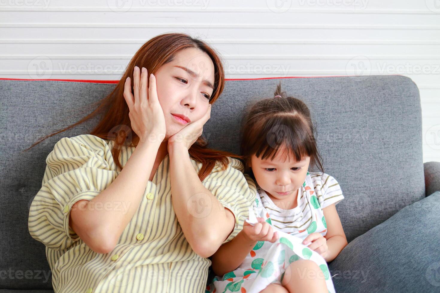 Aziatisch single mam hoofdpijn van verhogen een ondeugend weinig meisje ze beide za Aan de sofa in de huis. familie concept. modern ouderschap, single moeder, hoe naar verhogen gelukkig kinderen. foto
