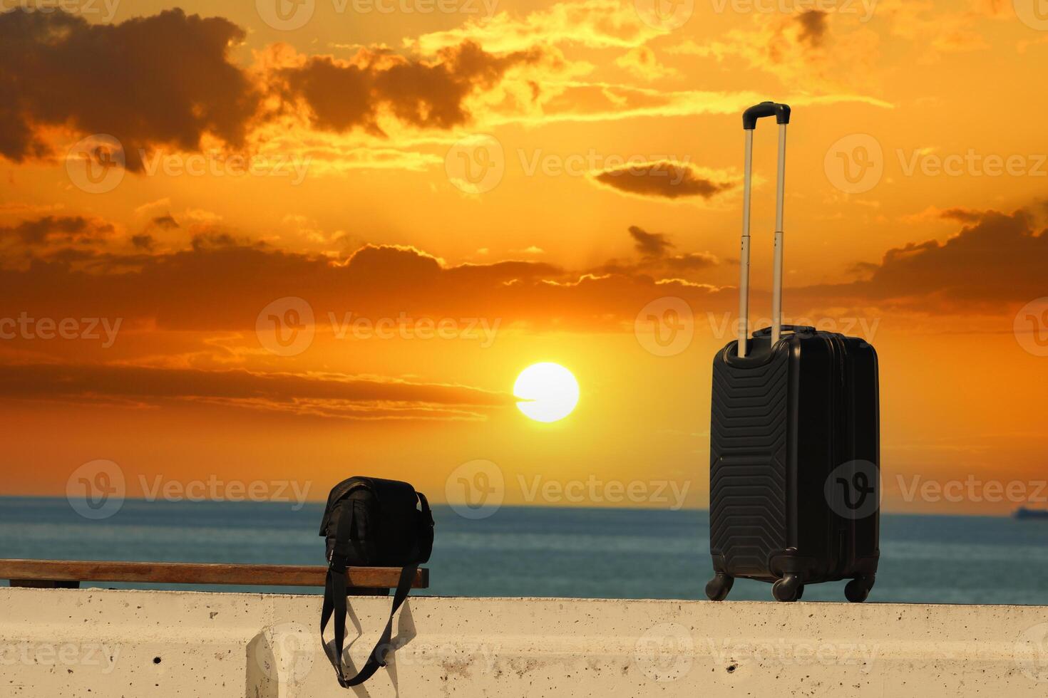 koffer en zak zijn staand Aan een strand met een zonsondergang in de background.travel en vakantie concept foto