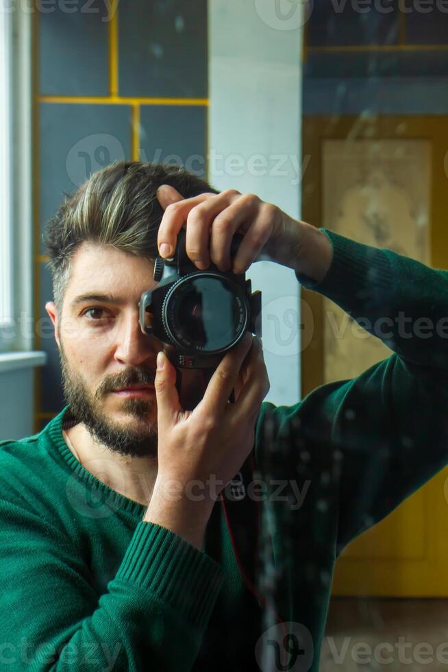 Mens nemen een afbeelding, jong Mens nemen een foto, een Mens met camera, reflectie van Mens in spiegel foto