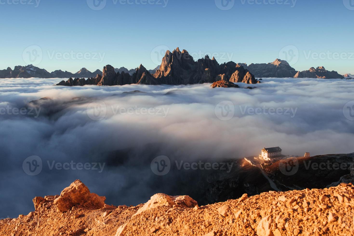 extreem broos oppervlak onder fotograaf die deze foto maakt. foto vanaf de rand van de heuvel en met mooie bergen met veel wolken en rechts gebouwen